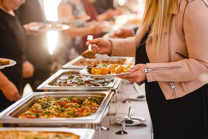 Buffet spread with various dishes and view of the cityscape